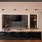 a sink and counter with a tv on the wall and barstools 