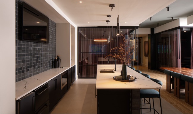 community kitchen with seating and a tv on the wall 